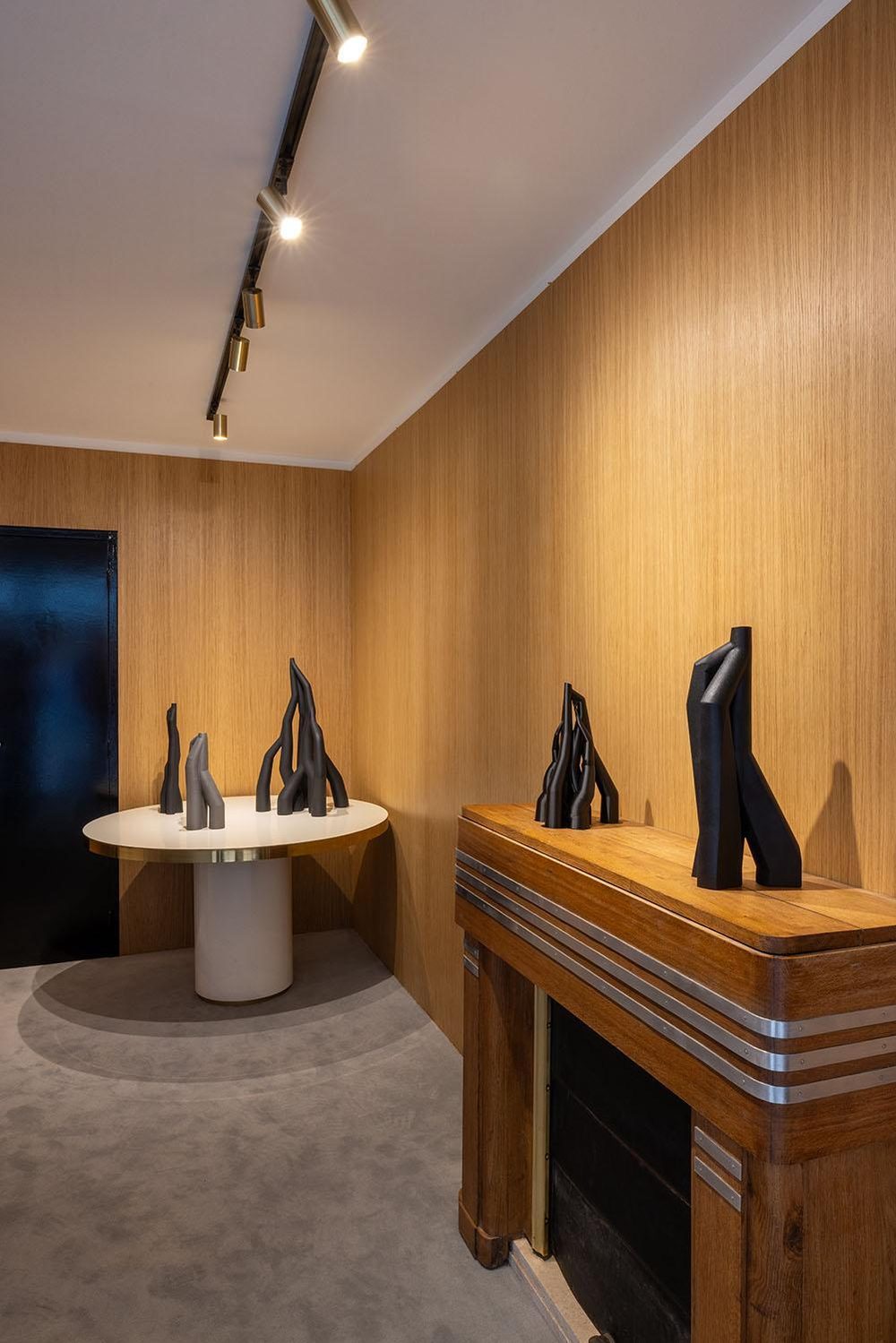 Gallery interior with Vorace sculptures on a table and a mantelpiece