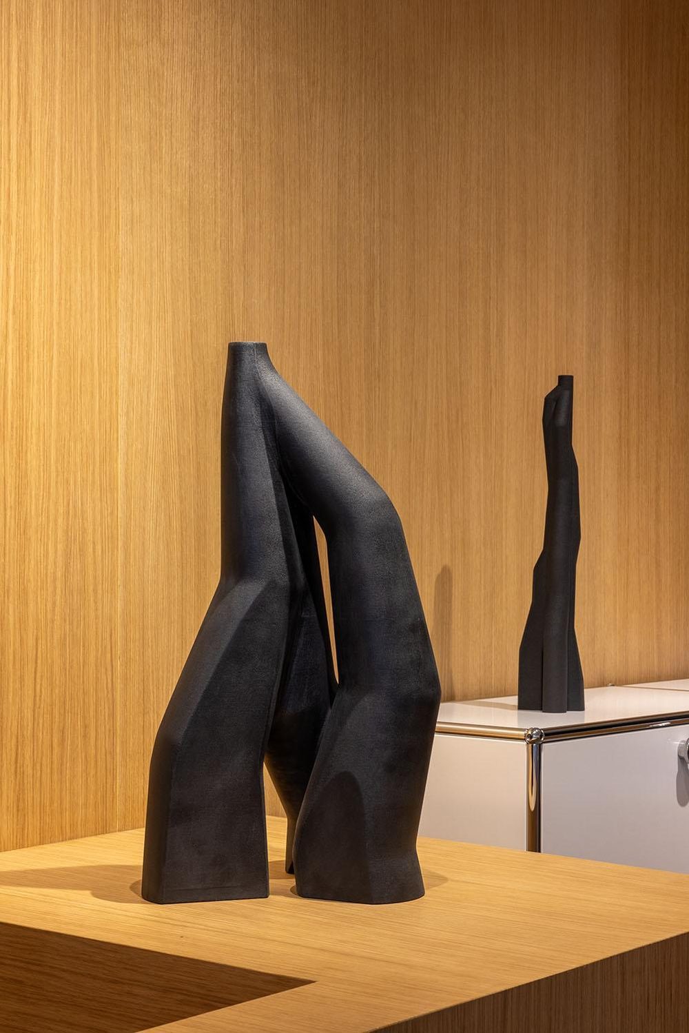 Detail of a black Vorace sculpture on a wooden plinth