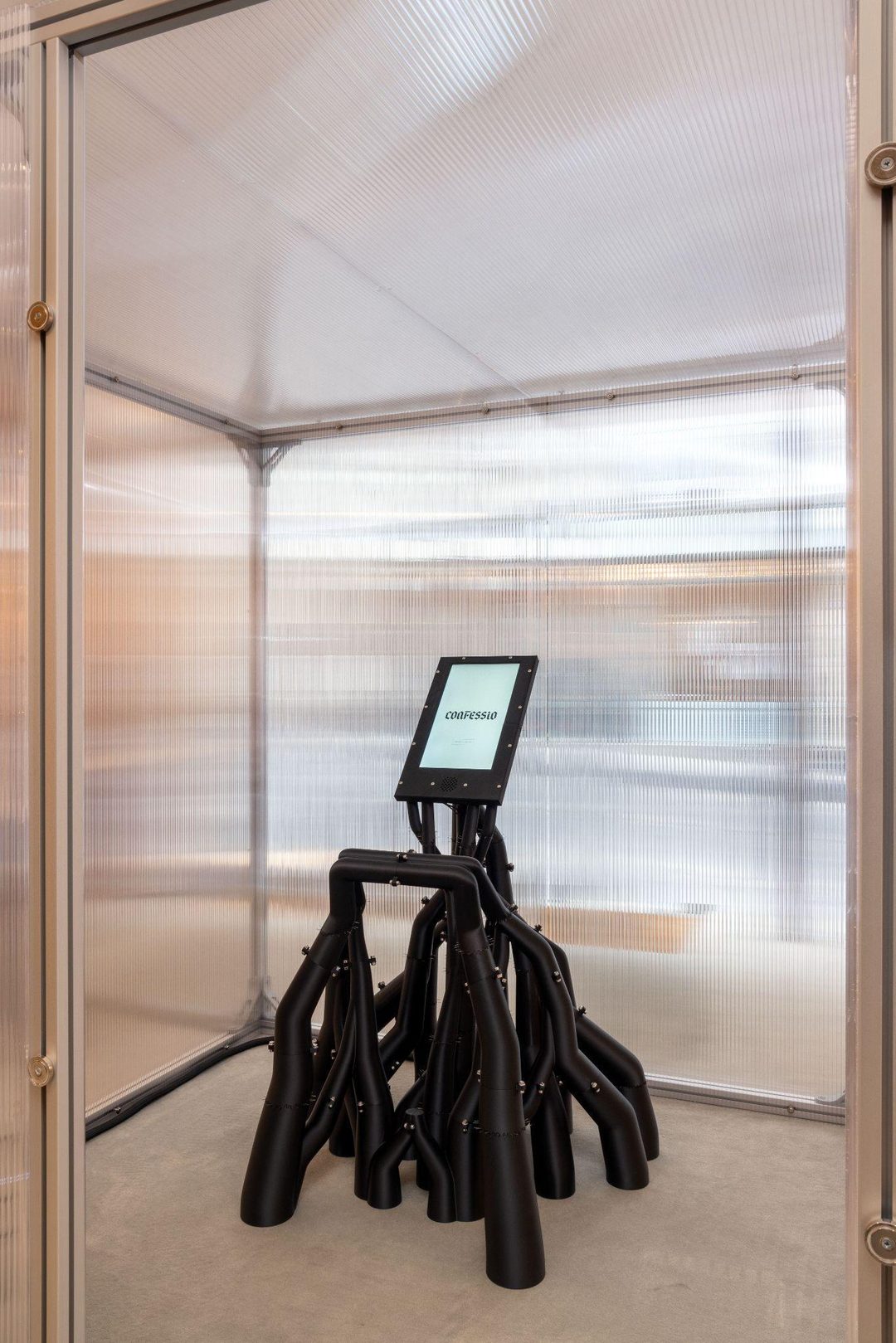 The totem inside the cube: a black branching form carrying a screen